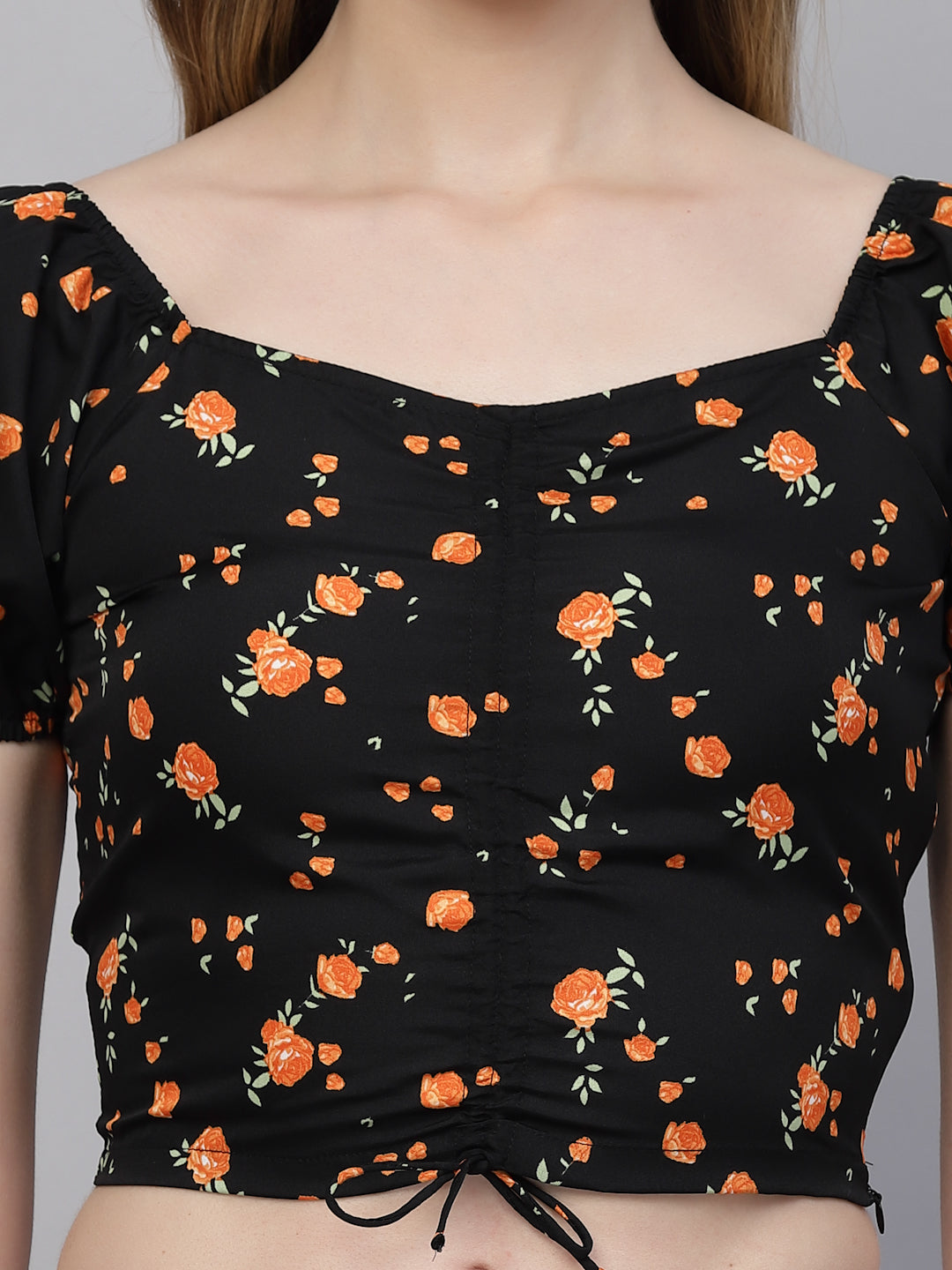 Black top with orange floral pattern worn by a person