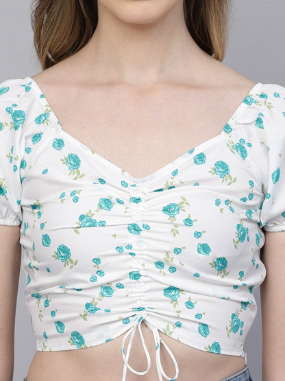 White crop top with blue floral pattern on a plain background