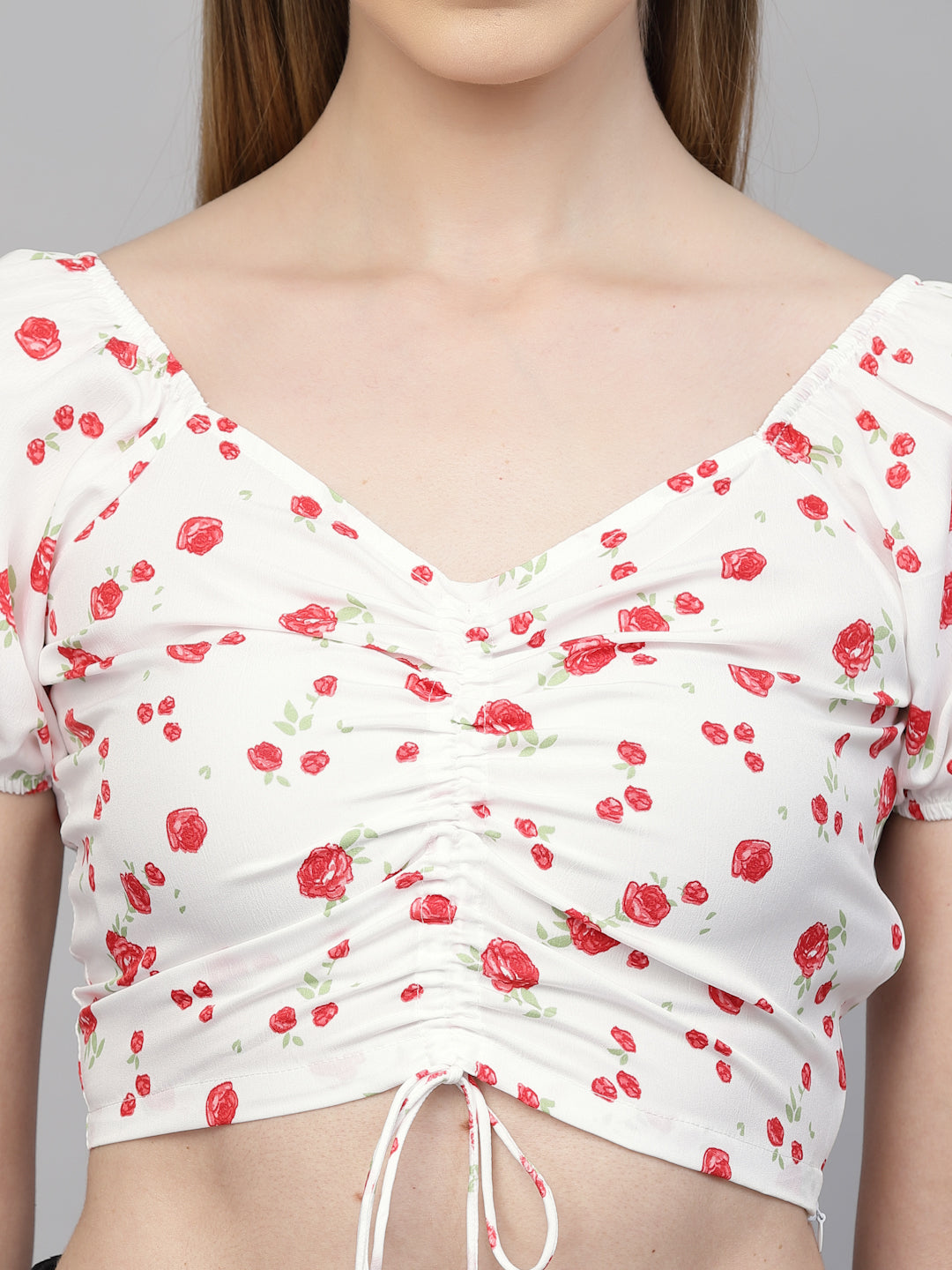 White top with red floral pattern on a mannequin against a gray background