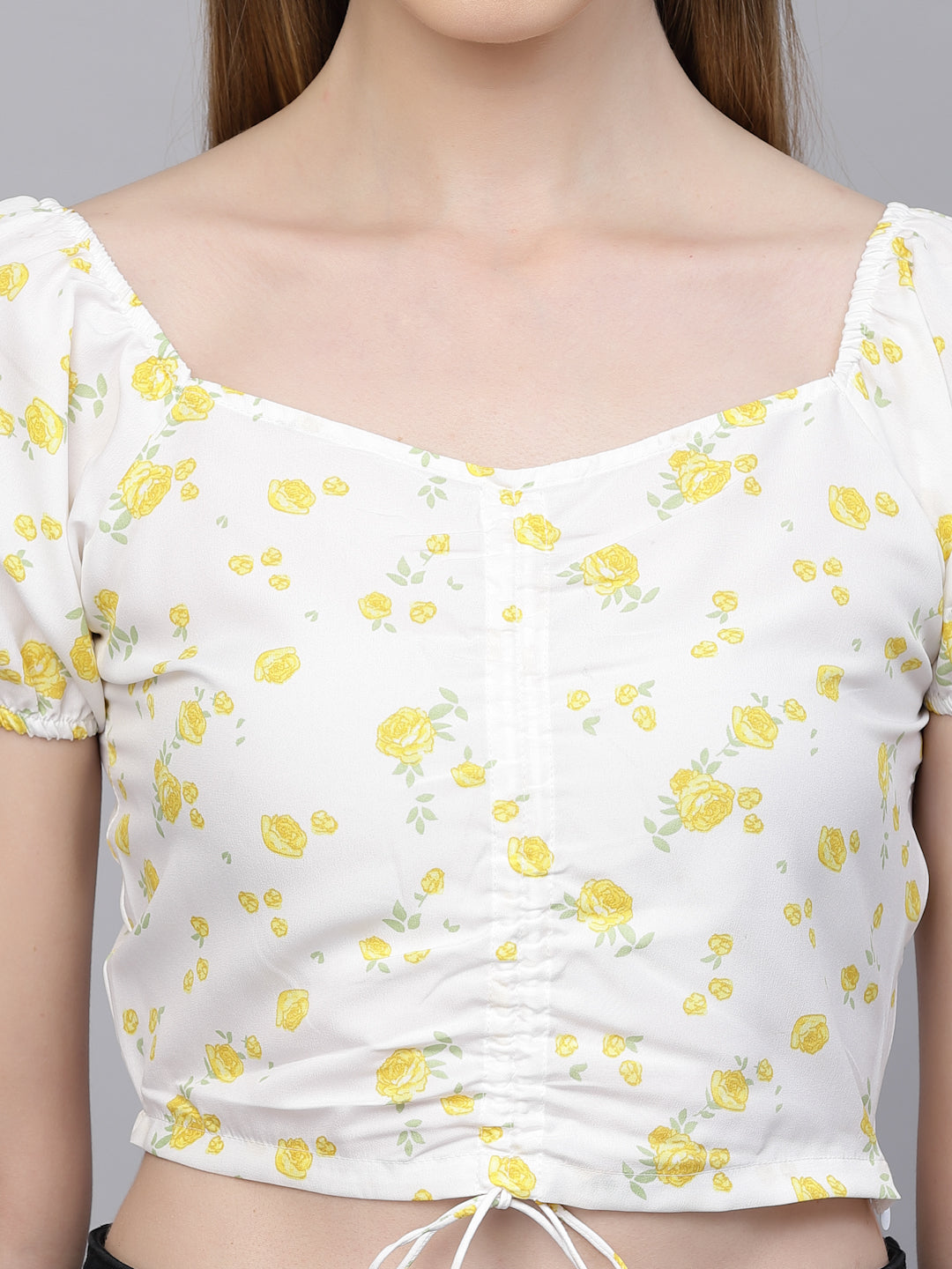 White top with yellow floral pattern worn by a person
