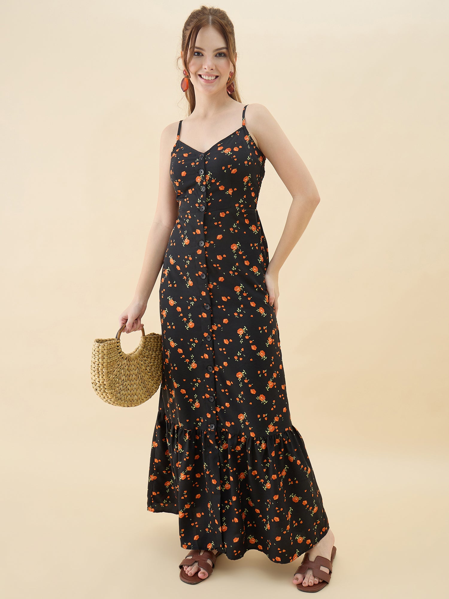 Woman wearing a black floral dress holding a straw bag on a beige background