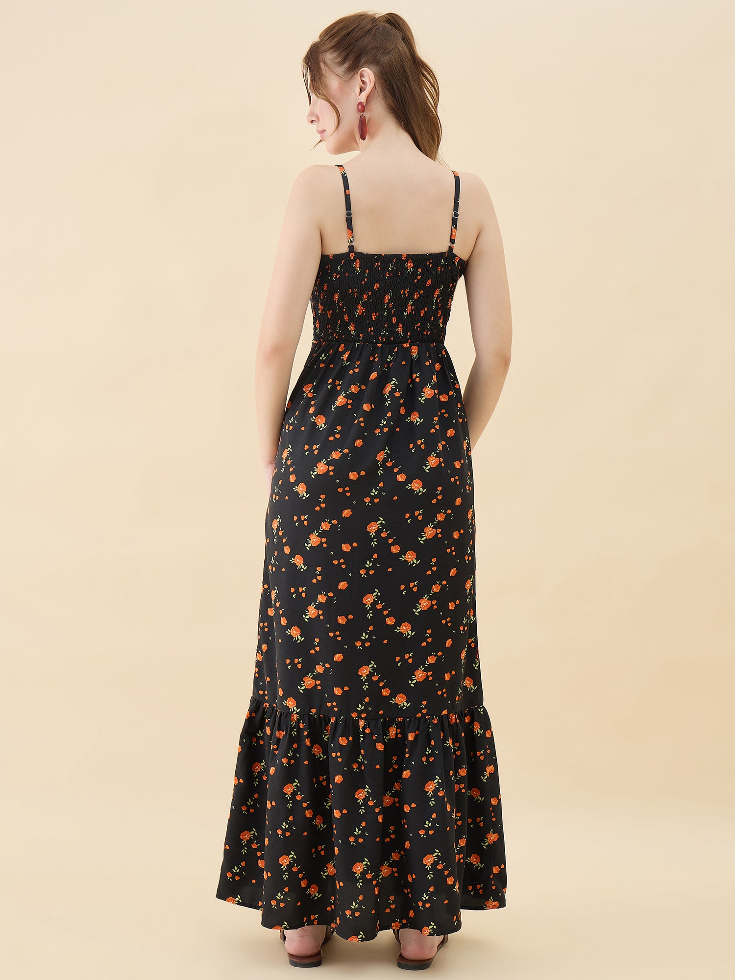 Woman wearing a black floral dress against a beige background