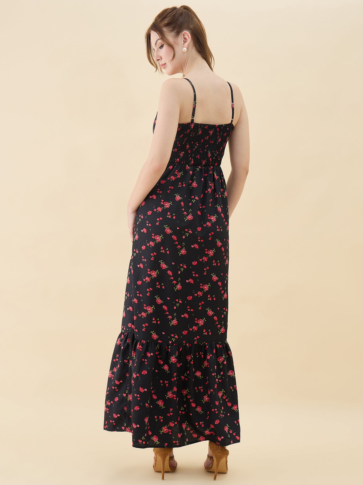Woman wearing a black floral dress against a beige background