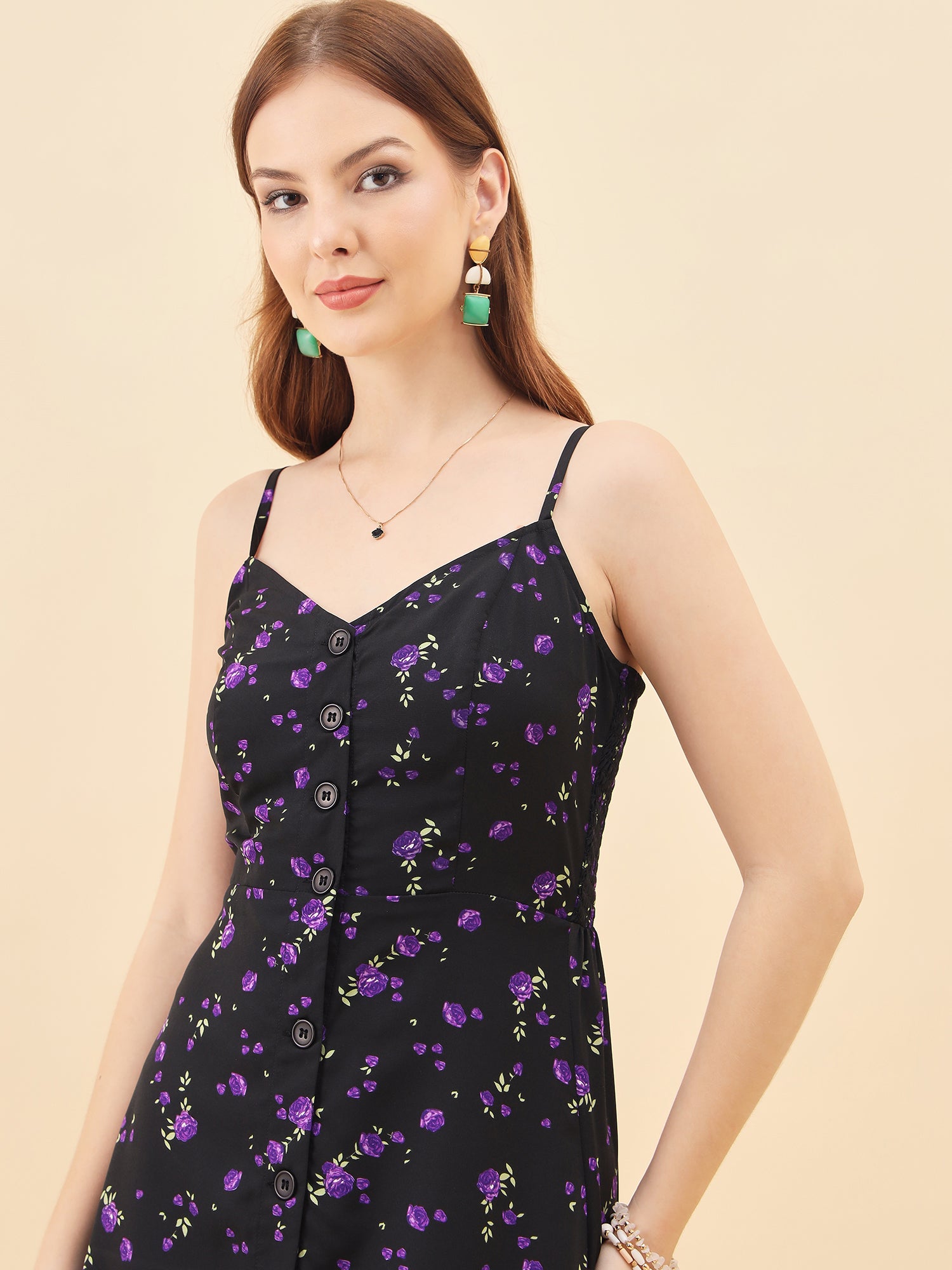 Woman wearing a black floral dress with a beige background