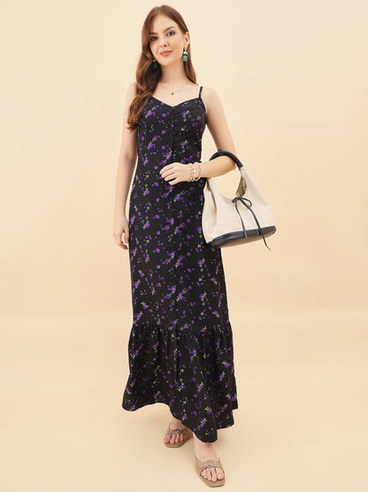 Woman wearing a black floral dress holding a white handbag on a beige background