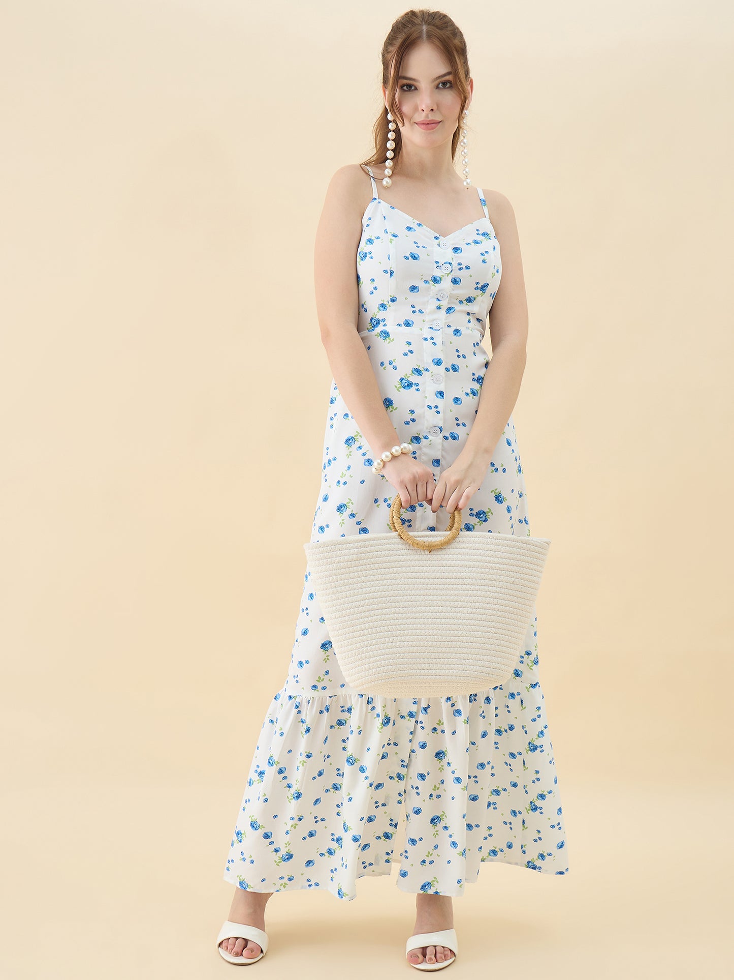 Woman in a floral dress holding a woven bag against a beige background