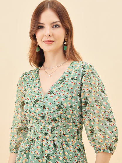 Woman wearing a green floral dress against a beige background