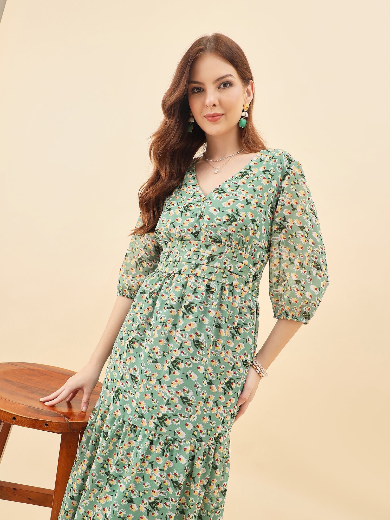 Woman wearing a green floral dress against a beige background