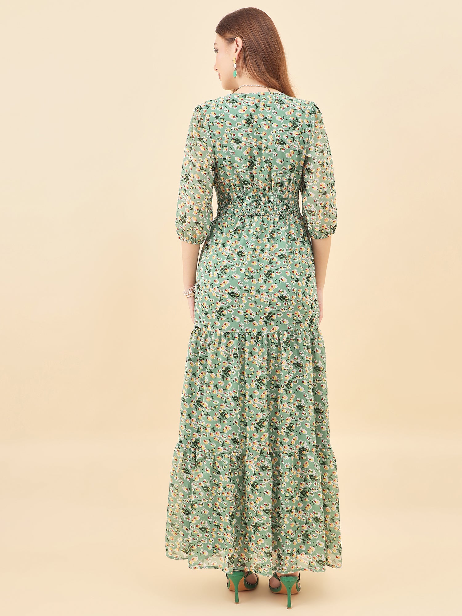 Woman wearing a green floral dress on a beige background