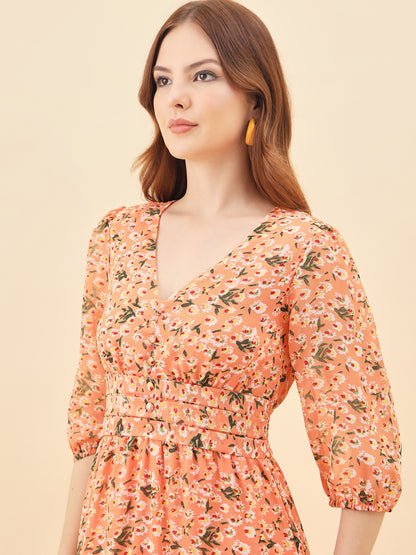 Woman wearing a orange floral dress against a beige background
