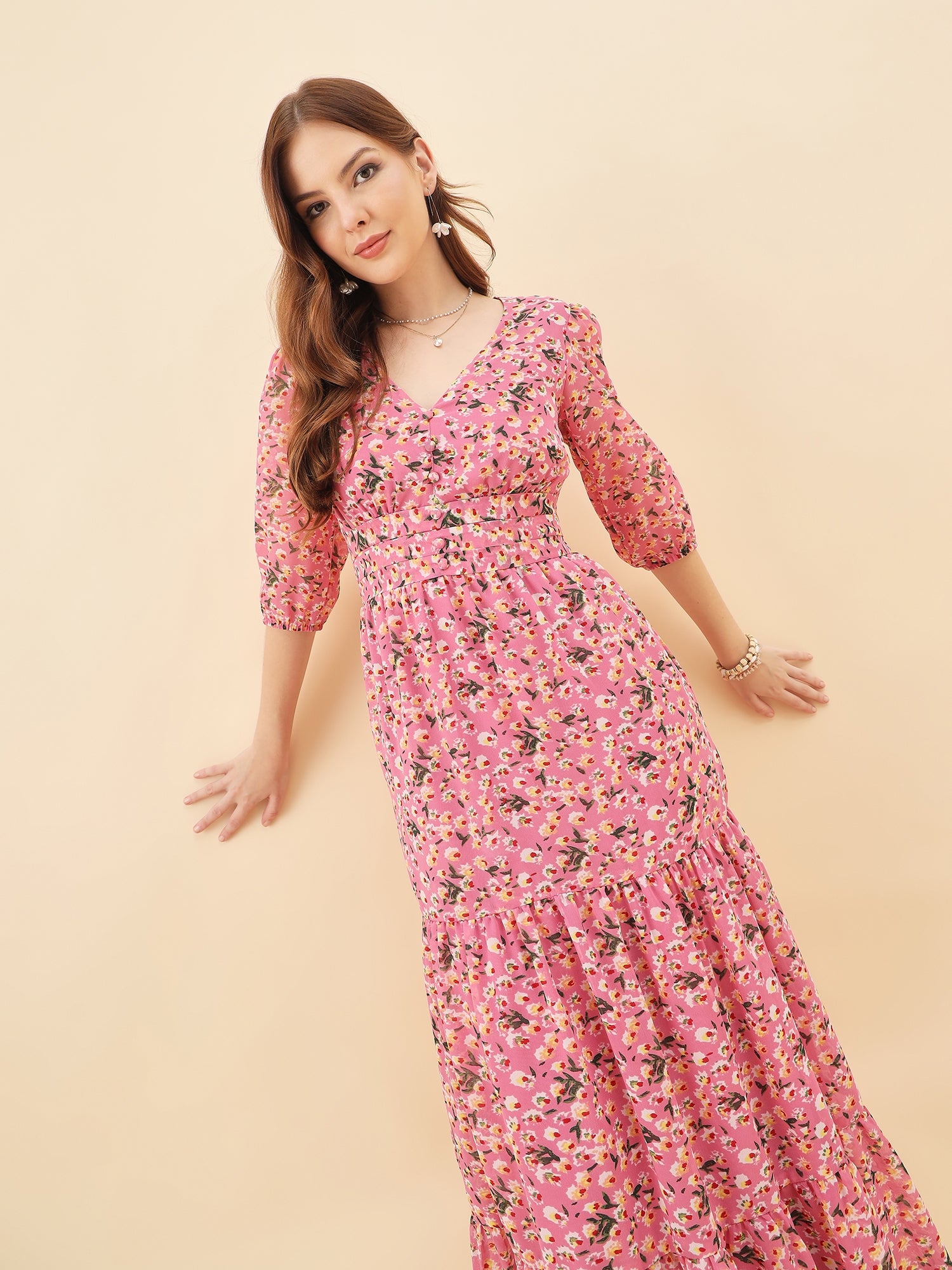 Woman wearing a pink floral dress against a beige background