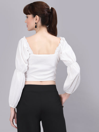 Woman wearing a white top with puffed sleeves on a gray background