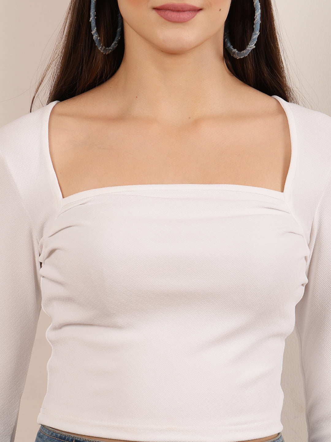 White long-sleeve top worn by a person with a neutral background