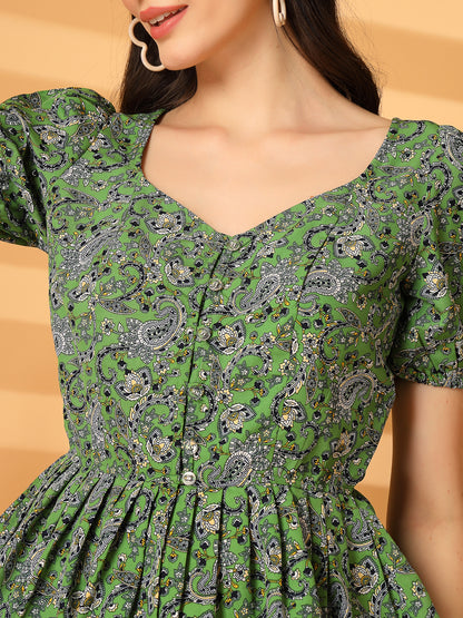 Green patterned dress worn by a person on a beige background
