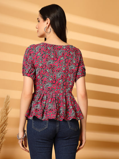 Woman wearing a red and black patterned top with a beige background