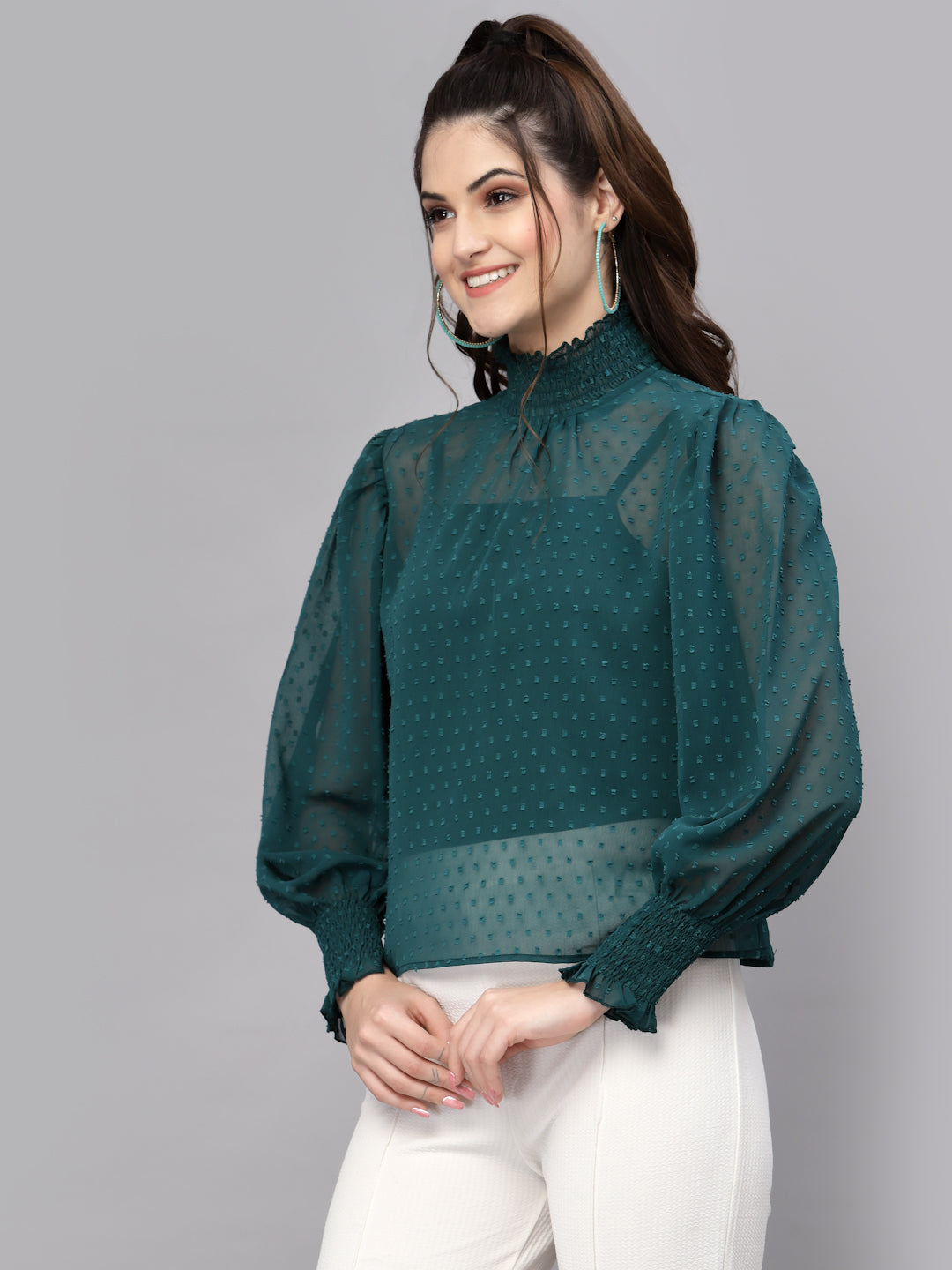 Woman wearing a green blouse with a gray background