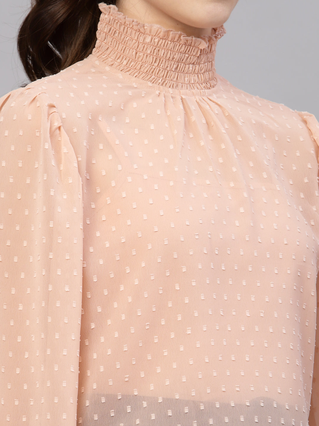 Peach top with white polka dots on a gray background