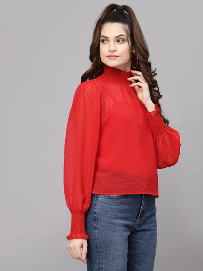 Woman wearing a red top and blue jeans on a gray background