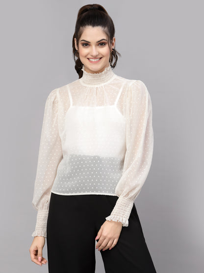 Woman wearing a white blouse with sheer sleeves on a gray background