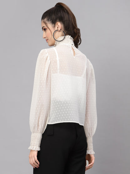 Woman wearing a white top with sheer sleeves on a gray background
