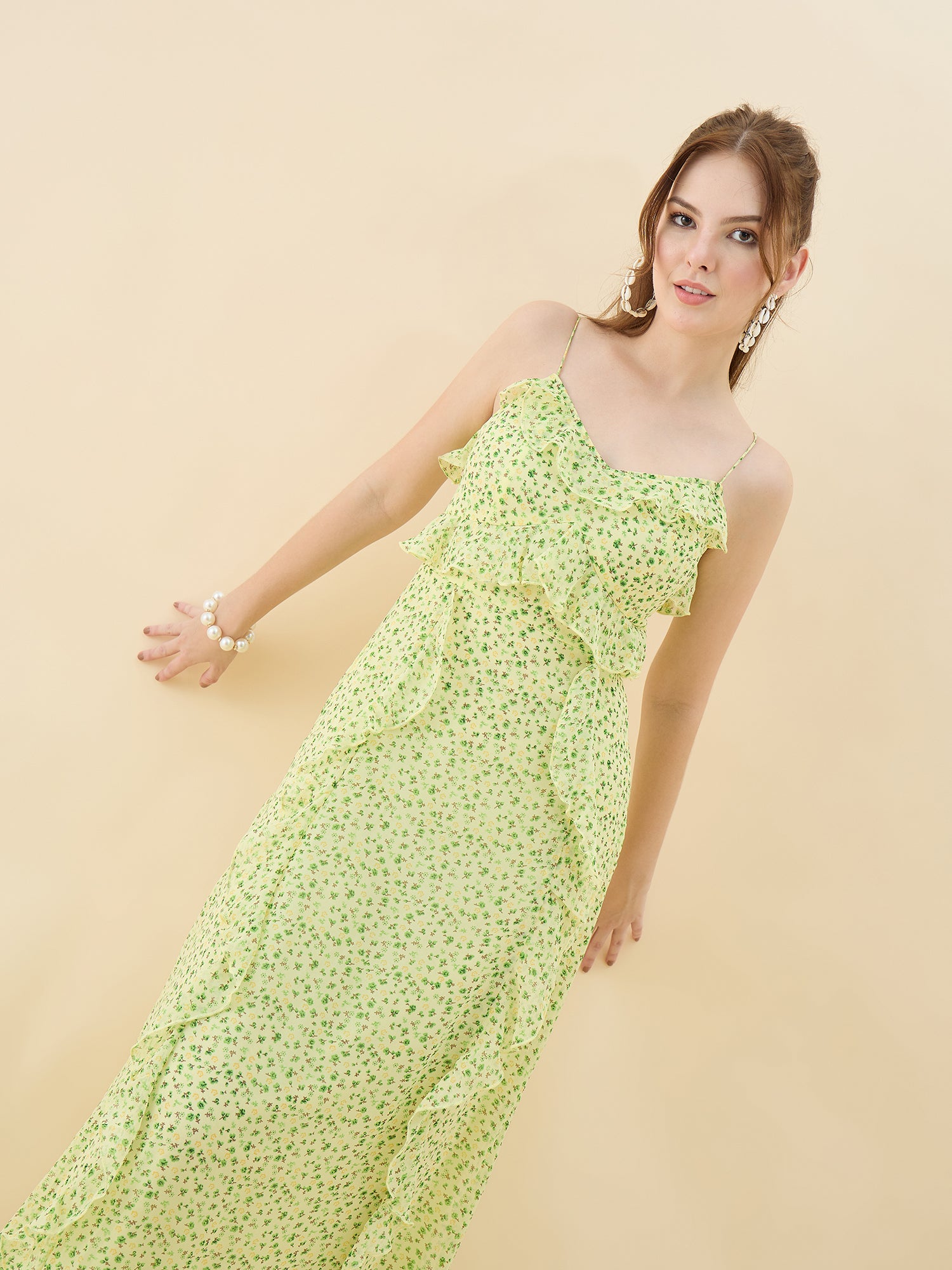 Woman wearing a light green floral dress against a beige background