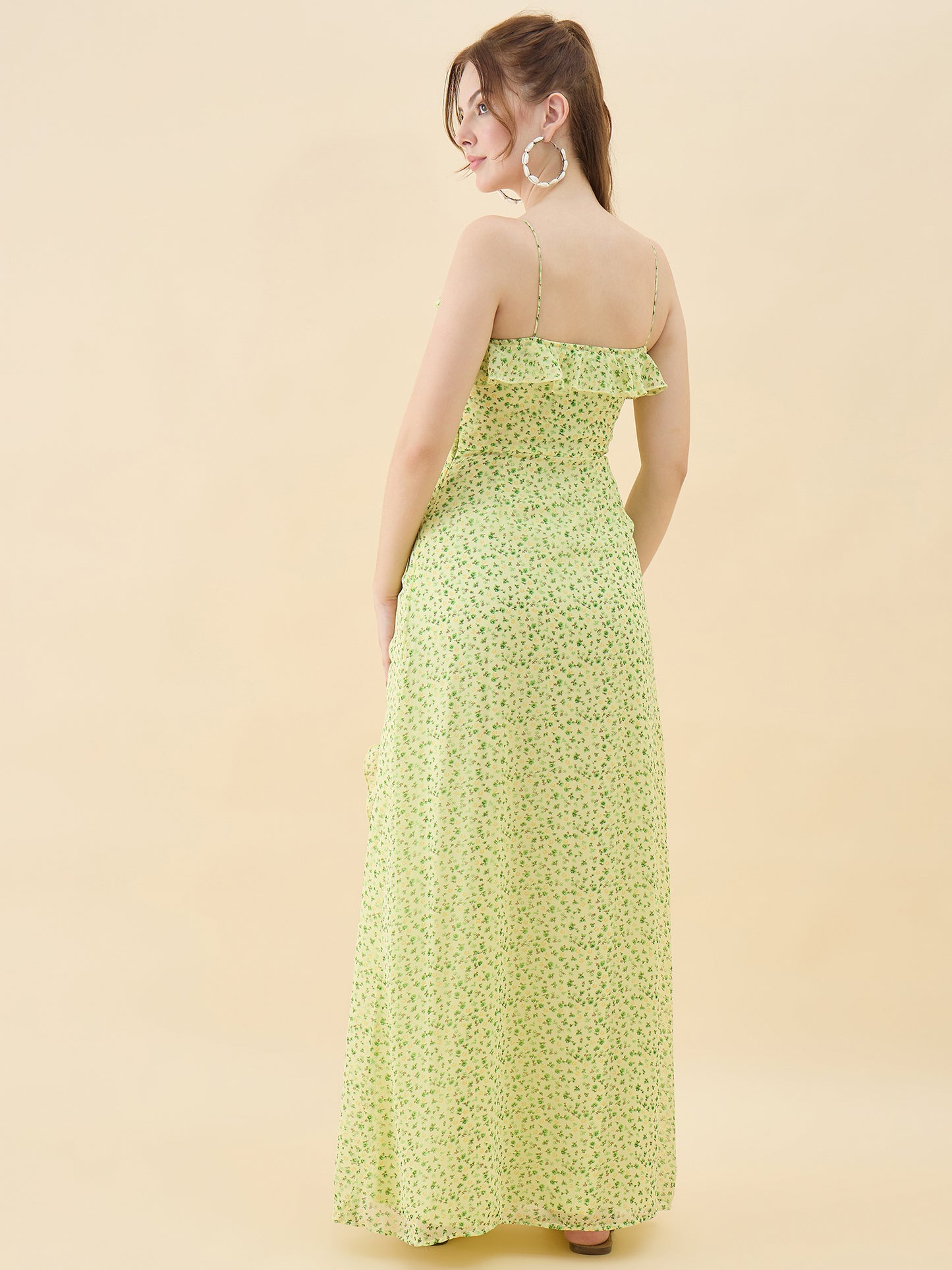 Woman wearing a strapless green floral dress against a beige background