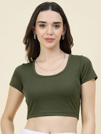 Woman wearing a green crop top against a beige background