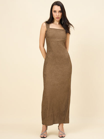 Woman wearing a brown dress against a beige background