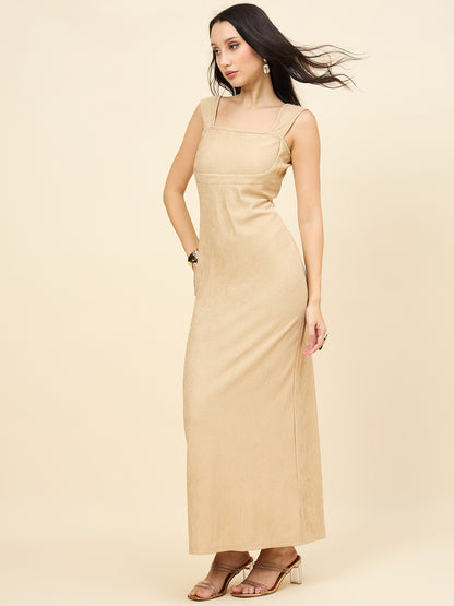 Woman wearing a beige dress against a plain background