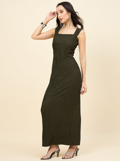 Woman wearing a green dress against a beige background