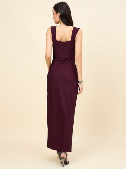 Woman wearing a long burgundy dress on a beige background