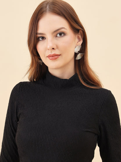 Woman wearing a black turtleneck sweater against a beige background