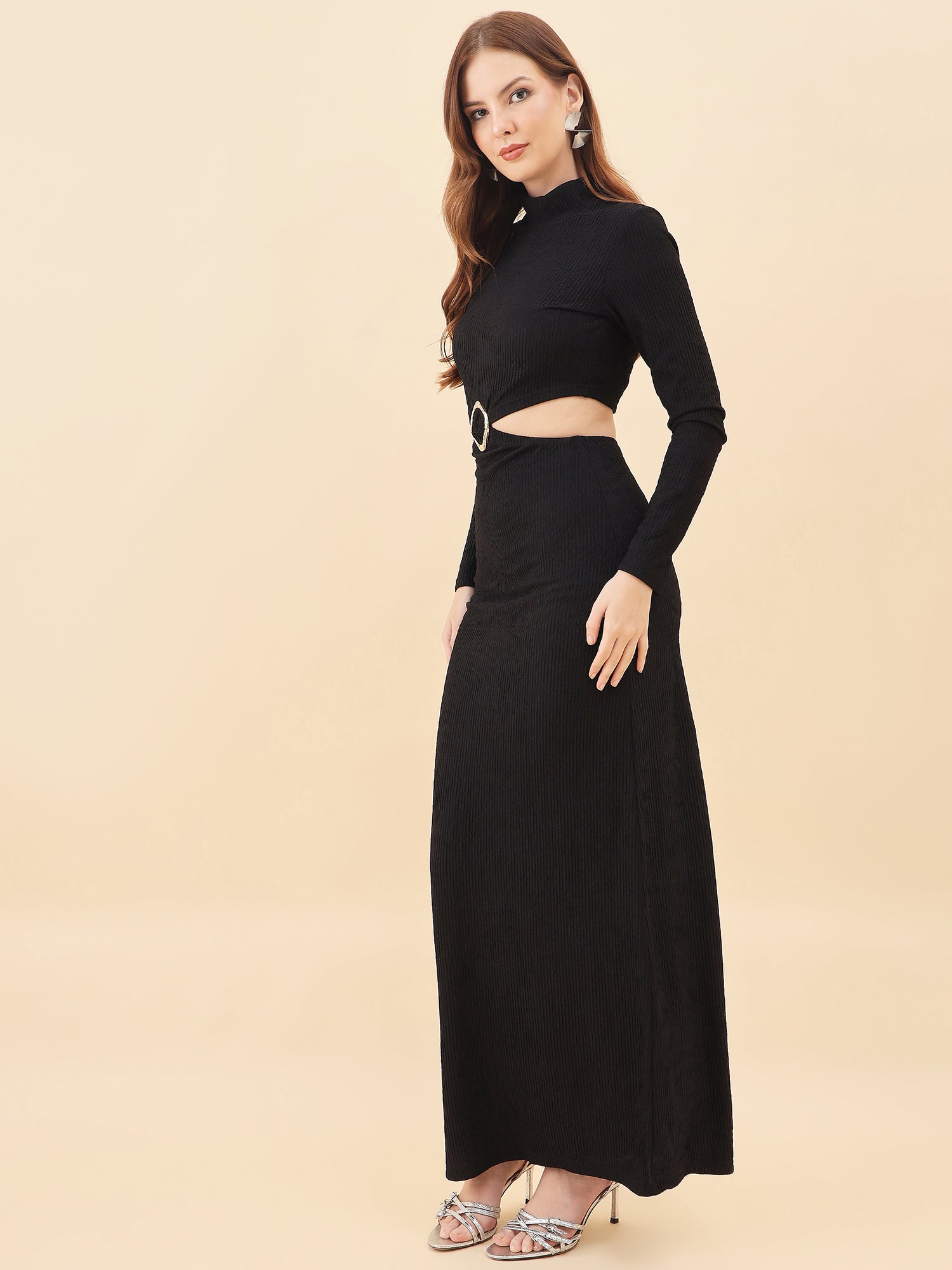 Woman wearing a black long-sleeve top and black skirt set on a beige background