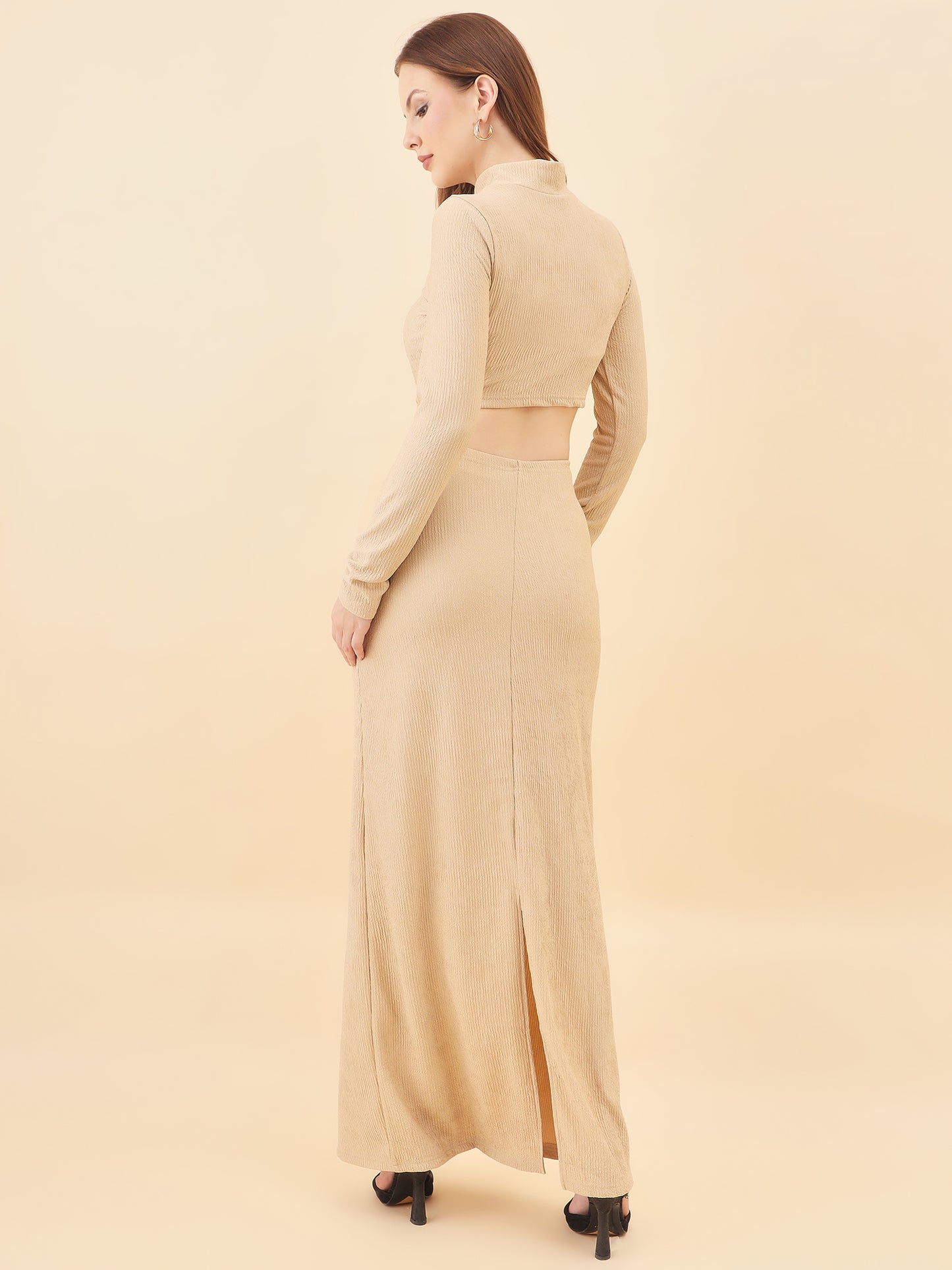 Woman wearing a beige long dress with a slit on a beige background