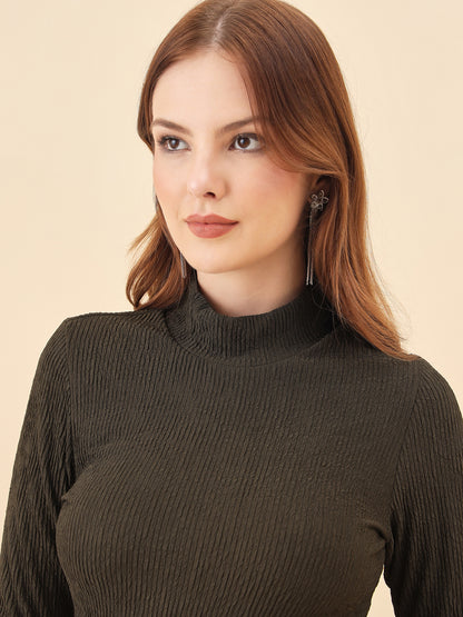 Woman wearing a dark ribbed sweater against a beige background