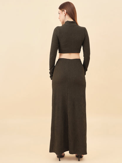 Woman wearing a long dark green dress with a matching top on a beige background