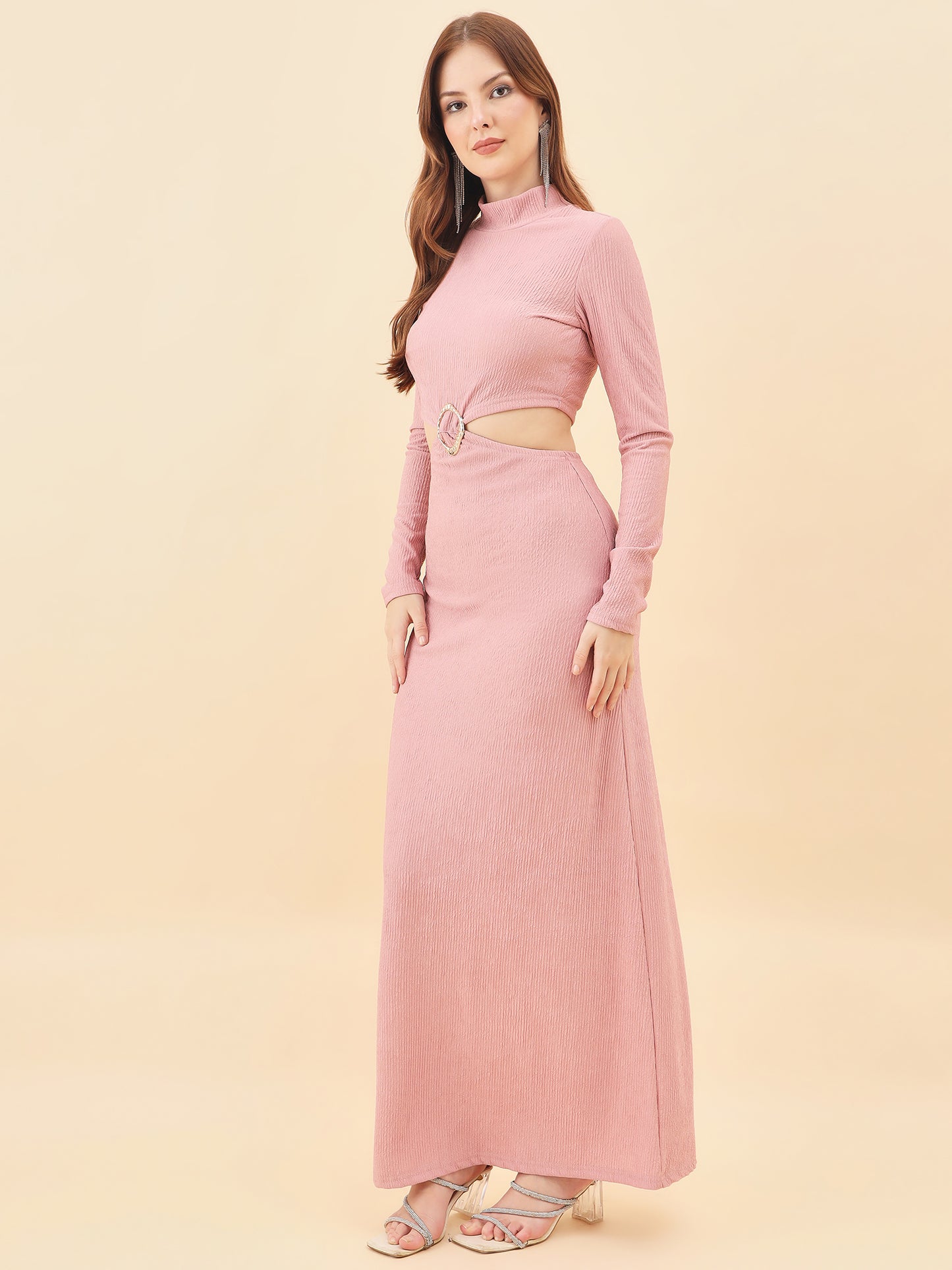 Woman wearing a pink long-sleeve dress with cutout design on a beige background