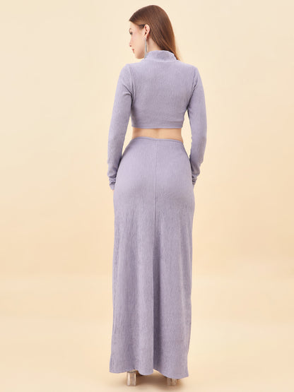 Woman wearing a long-sleeve crop top and maxi skirt set on a beige background