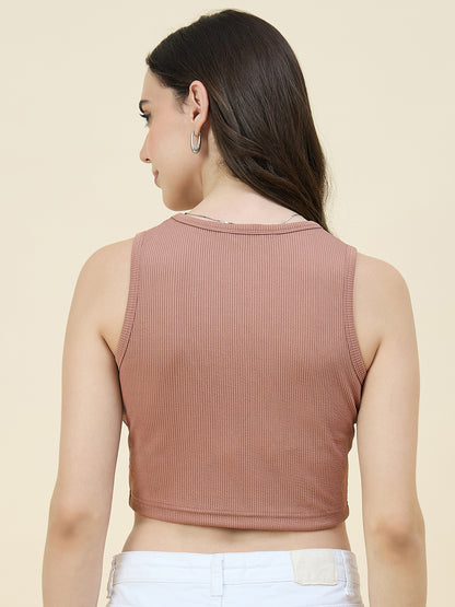 Woman wearing a cream ribbed tank top against a beige background