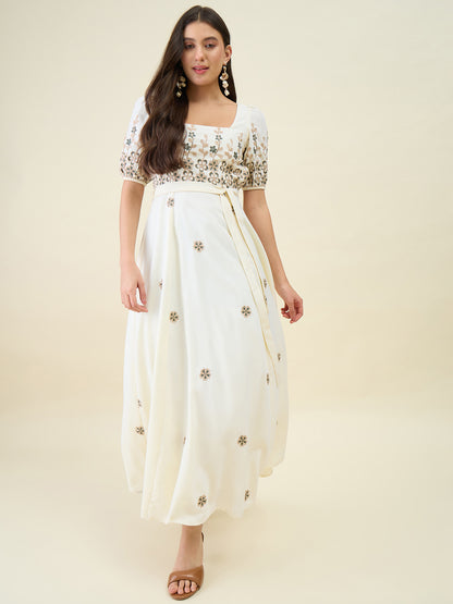 Woman wearing a white dress with floral patterns on a beige background