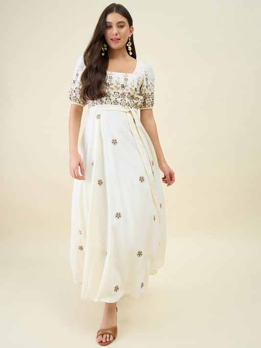 Woman wearing a white dress with floral patterns on a beige background