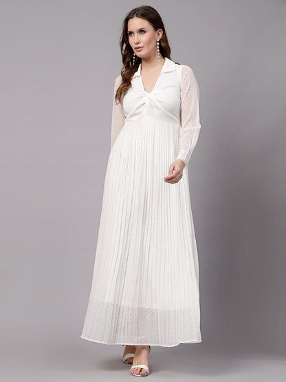A woman wearing a white fit and flare dress with long sleeves and a V-neckline.