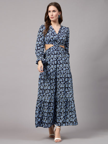 A woman wearing a blue floral fit & flare dress with three-quarter sleeves and a V-neckline, paired with white open-toe heels.