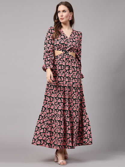 A woman wearing a fit and flare black and pink floral dress with 3/4 sleeves and a V-neck neckline.