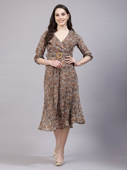 A woman standing and posing in a fit and flare dress with cuff sleeves and a printed pattern.