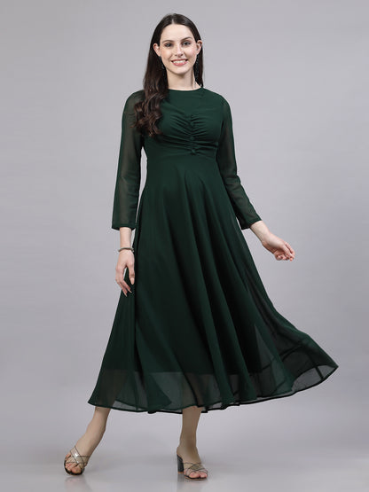 A woman wearing a green solid fit and flare dress with long sleeves and a round neckline.