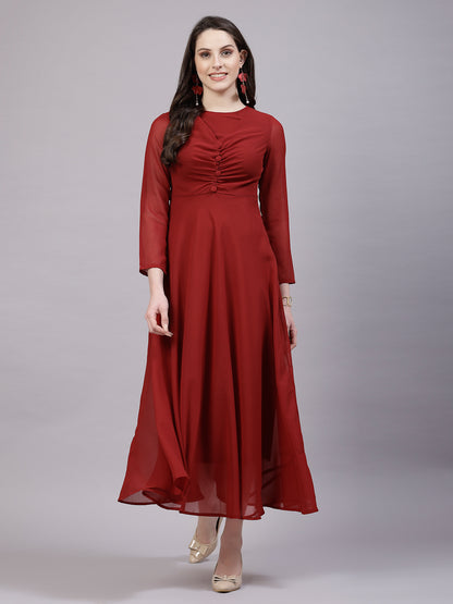 A woman wearing a fit and flare maroon solid dress with long sleeves and a round neckline.